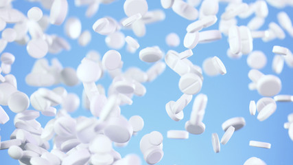 Freeze motion of flying pills on blue background