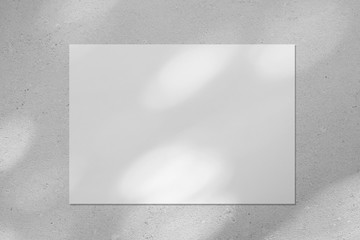 Empty white horizontal rectangle poster or business card mockup with diagonal dappled light spots on gray concrete wall. Flat lay, top view. For advertising, brand design, stationery presentation. - obrazy, fototapety, plakaty
