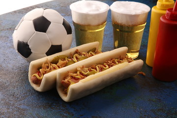 Grilled hot dogs with mustard and ketchup on the table with draft beer for football soccer party...