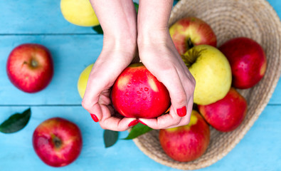 Apple in woman`s hands on  blue background