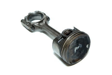 The used and dirty piston with the connecting rod from the sport engine isolated in a white background. 