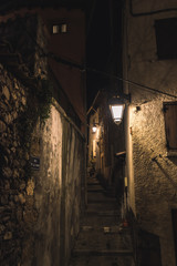 A medieval French old village alley with stairs at night lit by streetlights  (Jan 10, 2020; shot at Coste Street in Puget-Theniers, France)