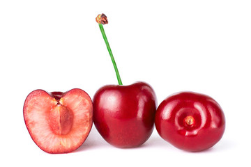 Three sweet cherries, one of them is cut in half, isolated on white background with clipping path