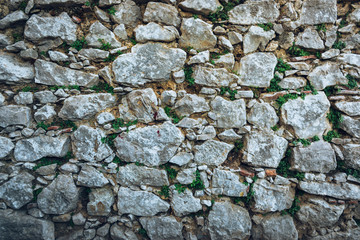 Old stone wall background with different sized bricks