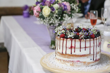 A detail picture of the big wedding cake with forest fruits and strawberries. 