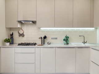 Fototapeta na wymiar Modern white bright kitchen interior with metal grey stove