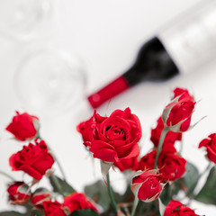 Red roses, flowers bouquet, wine and glasses for wine on white background. Women's Day, Valentine's Day, 8 March, Birthday. Flat lay, top view, copy space