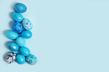 Decorated blue easter eggs on a turquoise background. Minimal holiday concept. Happy easter background. Creative painting of eggs at home, the idea of simple drawings for coloring,