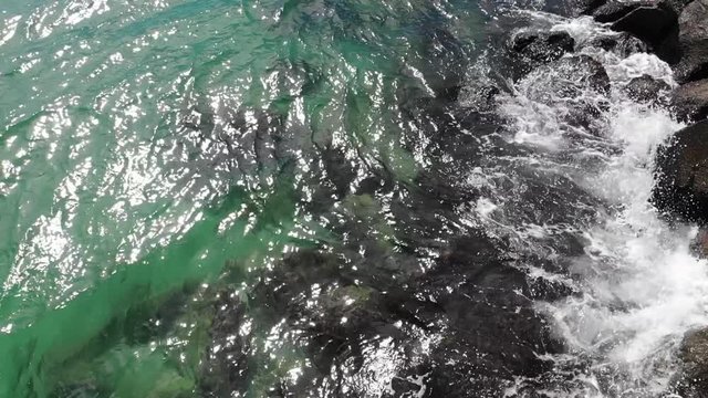Slowmotion Birdseye Aerial View of Sea Waves Breaking on Coastal Rampart Under Summer Sunlight