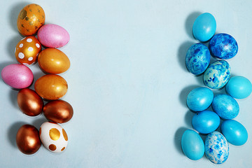 Decorated golden and blue easter eggs on a turquoise background. Minimal holiday concept. Happy easter background. Creative painting of eggs at home, the idea of simple drawings for coloring, 