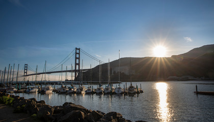 Fototapeta na wymiar Sunset at the marina under the Golden Gate Bridge on a foggy day by the bridge