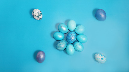 Decorated blue easter eggs on a turquoise background. Minimal holiday concept. Happy easter background. Creative painting of eggs at home, the idea of simple drawings for coloring, a place for text,