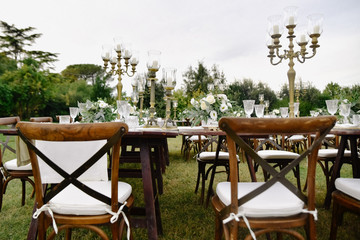 Decorated with floral compositions wedding celebration table with brown chiavari chairs guests...