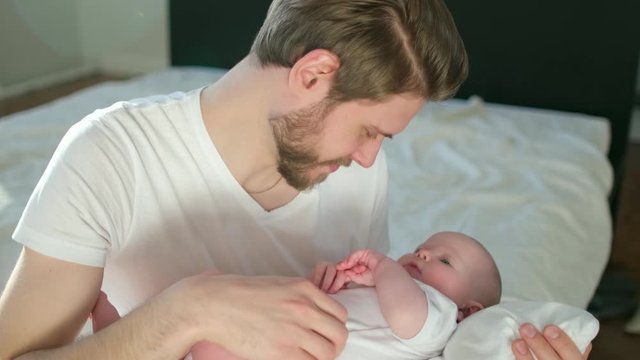 Happy family. Portrait of bearded father and newborn baby girl hugging. Paternity Parenthood happiness. Loving dad enjoying caring playing with little child. healthy childcare, love. 4 K Slow-motion