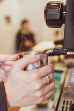 Professional barista making latte coffee in a coffeeshop in London