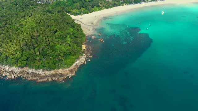 Nice rocks forested island, aerial panorama of Ko Pu against mountainous Phuket landscape on background. Deep tropical jungle thicket covering stony islend.Boat sailing. Aerial