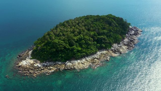 Nice rocks forested island, aerial panorama of Ko Pu against mountainous Phuket landscape on background. Deep tropical jungle thicket covering stony islend.Boat sailing. Aerial