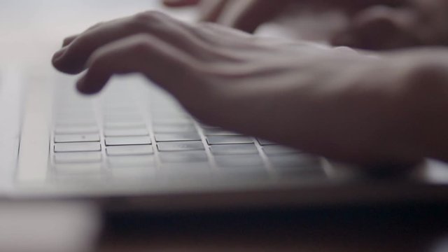 woman hands typing on a laptop working at the office close up shot