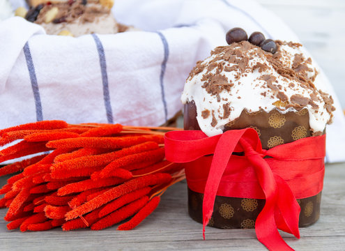 Traditional Easter bread with red ribbon and dried red flowers. Easter holiday background.