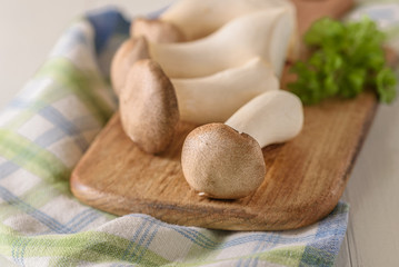 Frische Pilze mit Petersilie auf einem Holzbrett