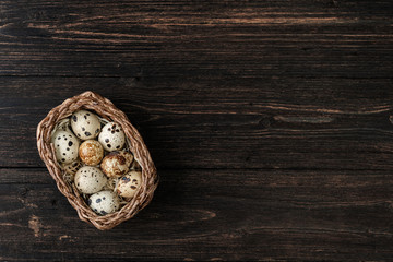 Obraz na płótnie Canvas Quail eggs in basket on wooden background