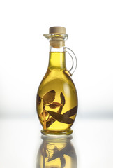 Small glass amphora with olive oil, with olive sprig and berries inside
