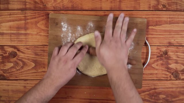 Stretching the dough with the wooden stick.