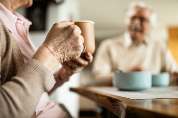 Close-up of mature woman having cup of coffee during breakfast.