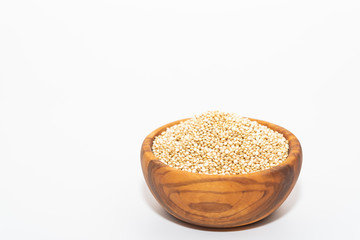 Raw quinoa in a wooden bowl isolated on white background with copy space