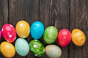 Different easter eggs on wooden background