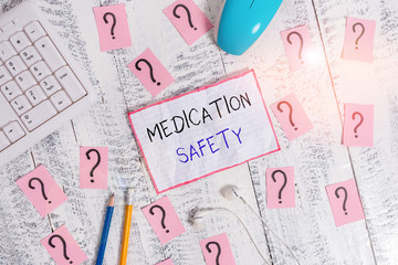 Handwriting text Medication Safety. Conceptual photo freedom from preventable harm with medication use Writing tools, computer stuff and math book sheet on top of wooden table