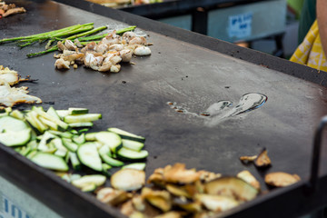 Cheff grill plate with vegetables and drop of oil ready to fry some meat.