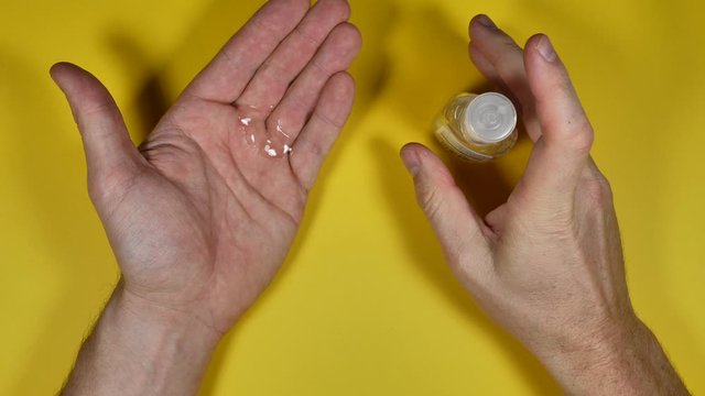 Close up shot of Male hands use disinfectant fumigation dispenser to sanitize hands.
