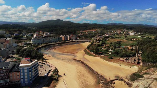 Aerial of sand bedding at ebb in Spanish fishing village. Filmed in San Ciprian, Spain