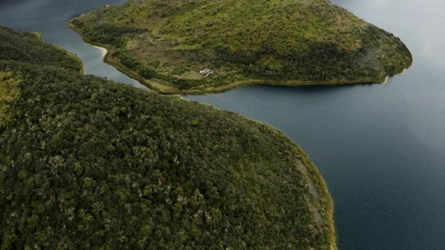 Aerial tilts up and reveals the Cuicocha Islands, Otavalo Ecuador.