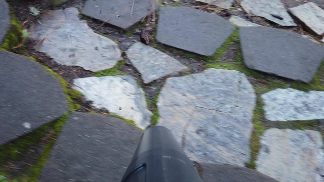 First person view of a hand held blower removing leaf and ground debris from steps