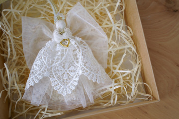 gift box with angel on wooden background