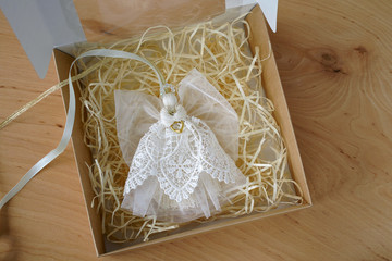 gift box with angel on wooden background