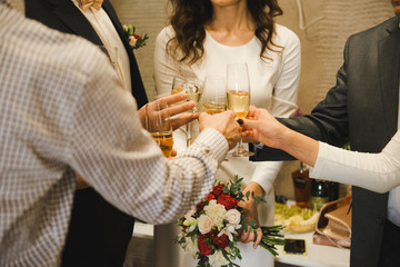 hands of happy people toasting and cheering with glasses of champagne, celebrating wedding