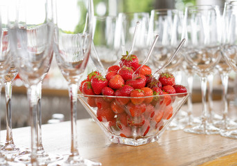 Transparent vase with strawberries on the table.