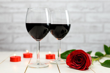 A glasses of wine, rose and burning candles