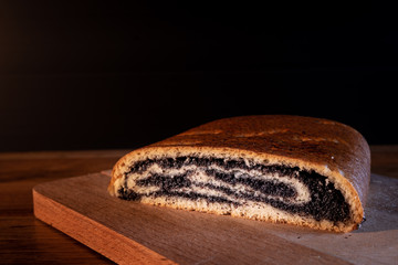 Homemade strudel with poppy seeds and salt on a wooden board