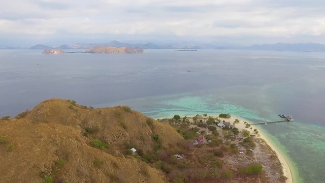 Aerial drone view of Pulau Kenawa located between Komodo National Park and Labuan Bajo, Flores, Indonesia. Small island with white sand beach surrounded by crystal clear turquoise water and coral reef