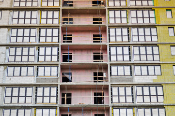 Obraz premium Windows and accessories of a new modern monolithic frame-block house under construction with windows, walls and balconies. Background, texture
