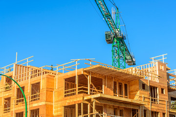 Your dream home. New residential construction house framing and green crane.