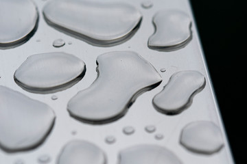 macro fotografía de gotas de agua sobre acero inoxidable