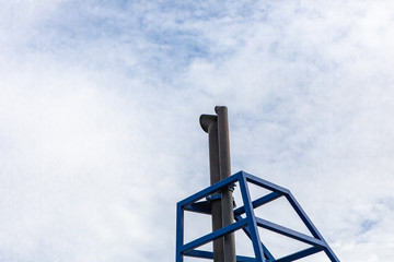 Close up of the exhaust pipe of a passenger ferry boat, protected by a blue metallic support. Technical ship equipments, industrial geometries.
