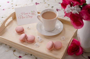 Fototapeta na wymiar Have A Nice Day Card with a Cup of Tea or Coffee with Pink Flowers and Cookies on a Wooden Serving Tray