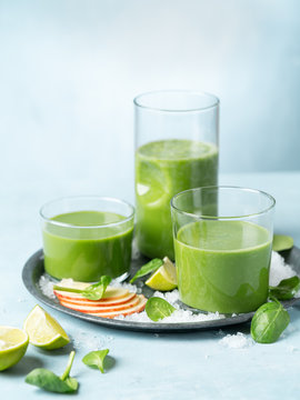 Green smoothie in glass with organic ingredients, vegetables on a light background with copy space. Selective focus. Food and drink, healthy dieting, nutrition, alkaline, vegan, vegetarian concept.
