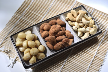 almond and cashew in the plate on the bamboo mat